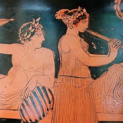 A flute girl serenades symposium guests on their couches.